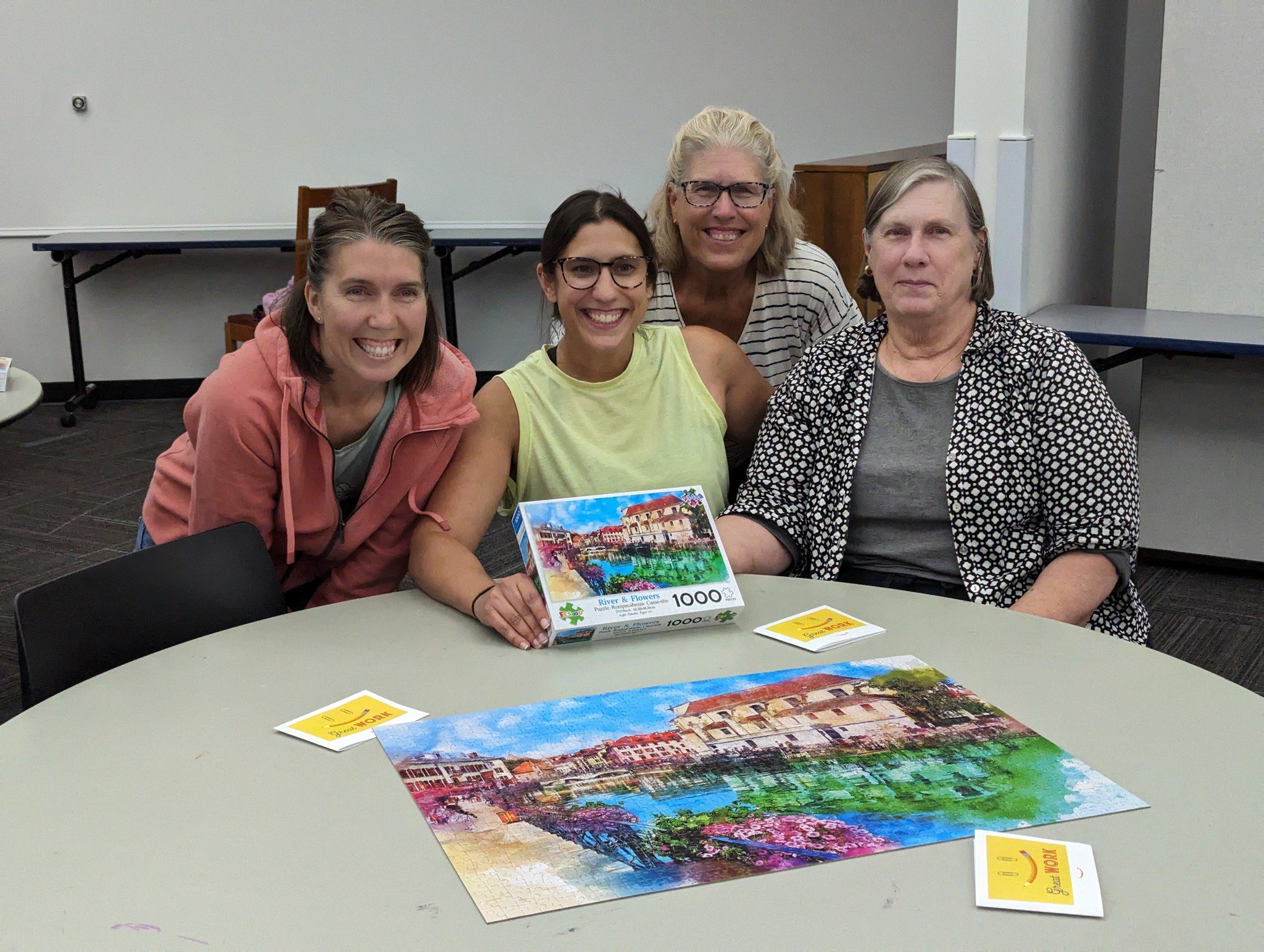 Group of patrons around a puzzle after winning the puzzle contest at the library.